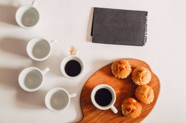 Bir fincan kahve. Çörekler. Yiyecek ve içecek. Boş bir kağıt parçası. bir not.