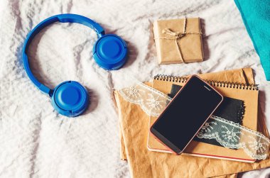 İş için telefon, ses kayıtları için kulaklık. Çelenk parlıyor.