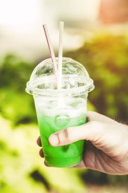 Kokteyl. Sıcak havada buz küpleri ve pipetlerle kokteyl. Meyvelerle dolu tropikal bir yerde.