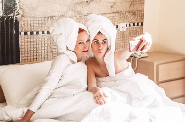 Anne ve kızı. Kızım telefonda hafızası için fotoğraf çekiyor. Mutlu bir aile.