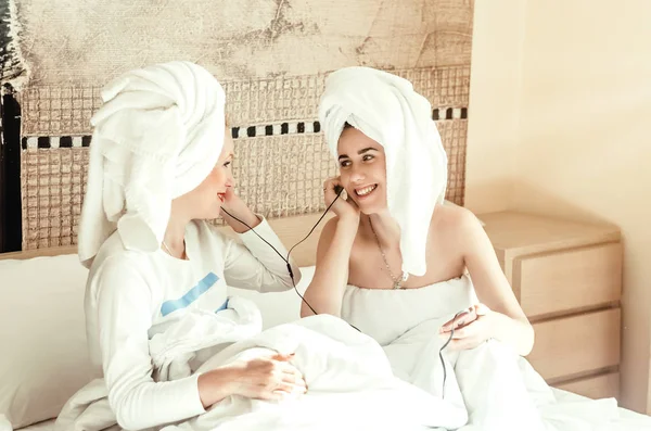 Anne ve kızı kulaklıkla müzik dinliyorlar. Birlikte vakit geçirin. Mutlu bir aile.