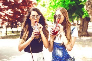 Kız arkadaşlar iletişim kurmak için buluşur. Buzlu içecek ve meyve suyu. Uzun saçlı. Güzel kızlar. yaz