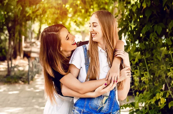 两个女朋友欢快地拥抱在一起 夏日在街上举行的会议 — 图库照片