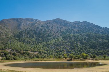Kretes 'in Beyaz Dağları' ndaki Omalos dağ köyündeki küçük kuruyan göl yaz boyunca açık gökyüzü altında çevresel değişiklikleri yansıtıyor..