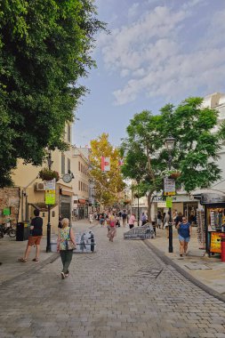 Gibraltar, UK. September 8, 2025. Tourists strolling through pedestrian streets under clear sky and sunny weather, lively city atmosphere