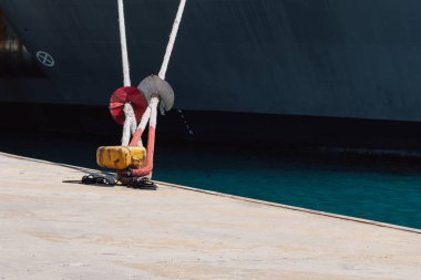 Rıhtımdaki iskeleye demirleme halatlarını kullanarak bir gemiyi demirlemek. İyi kalite fotoğraf.