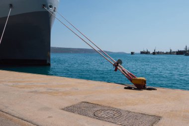 Rıhtımdaki iskeleye demirleme halatlarını kullanarak bir gemiyi demirlemek. İyi kalite fotoğraf.