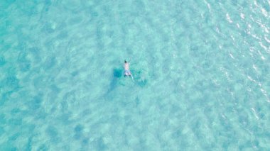 Young man snorkeling with mask in crystal clear turquoise sea water, enjoying summer vacation, underwater adventure and outdoor leisure activity