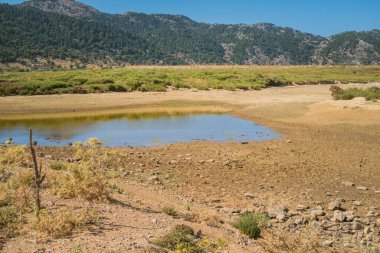 Yunanistan 'ın Girit kentindeki Beyaz Dağlar' daki Omalos köyünde bir gölün kuruması sırasında gözlemlenen iklim değişikliği sorunu, güneşli gökyüzü altındaki çevre sorunlarını vurguluyor