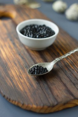 Ahşap tahta üzerinde metal bir kaşık taze Siyah havyar