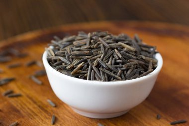 Tahta üzerinde seramik kasede siyah pirinç..