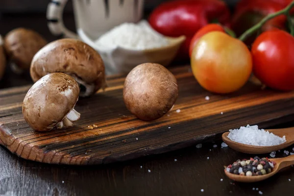 Raw mushrooms on wooden board. Three mushrooms on kitchen