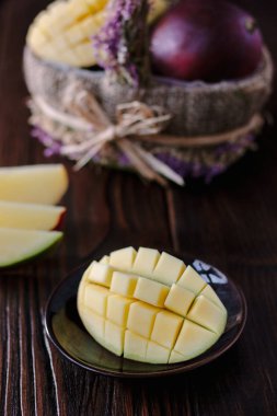 Taze ve sulu mango, ahşap masanın üzerinde ikiye bölünmüş.