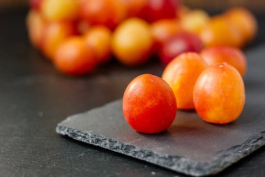 Vahşi erikler siyah taş tahtada meyveler