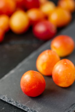 Vahşi erikler siyah taş tahtada meyveler