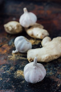 Siyah kırsal yüzeyde zencefil kökü ve sarımsak..