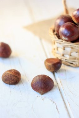 Sepette Beyaz ahşap masa üzerinde kestane.