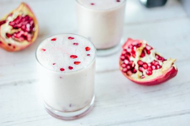 Geleneksel Hint Lassi 'si. Nar tohumlu beyaz masada soğuk yoğurt içeceği.