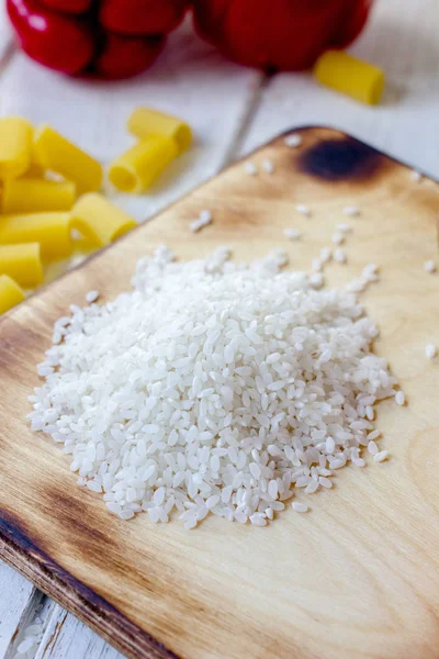 Tablero de cocina con arroz crudo seco — Foto de Stock