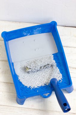 Mavi boya tepsisi içinde boya rulosu ve boya var.