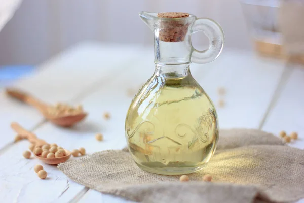 Soy bean oil in glass bottle with soybeans around it