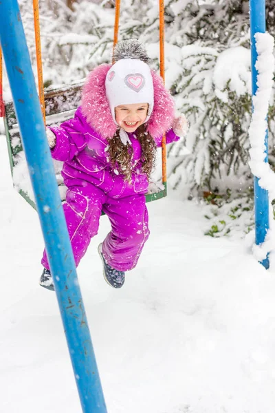 Маленькая Девочка Веселится Качелях Зимой Утром — стоковое фото
