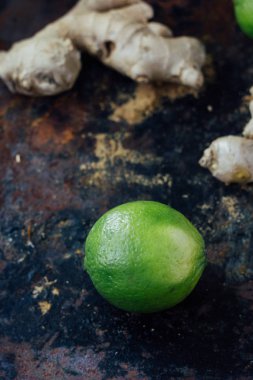 Siyah köy yüzeyinde yeşil kireç ve zencefil.