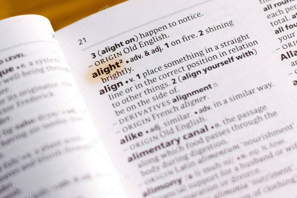 The word or phrase Alight in a dictionary highlighted with marker.