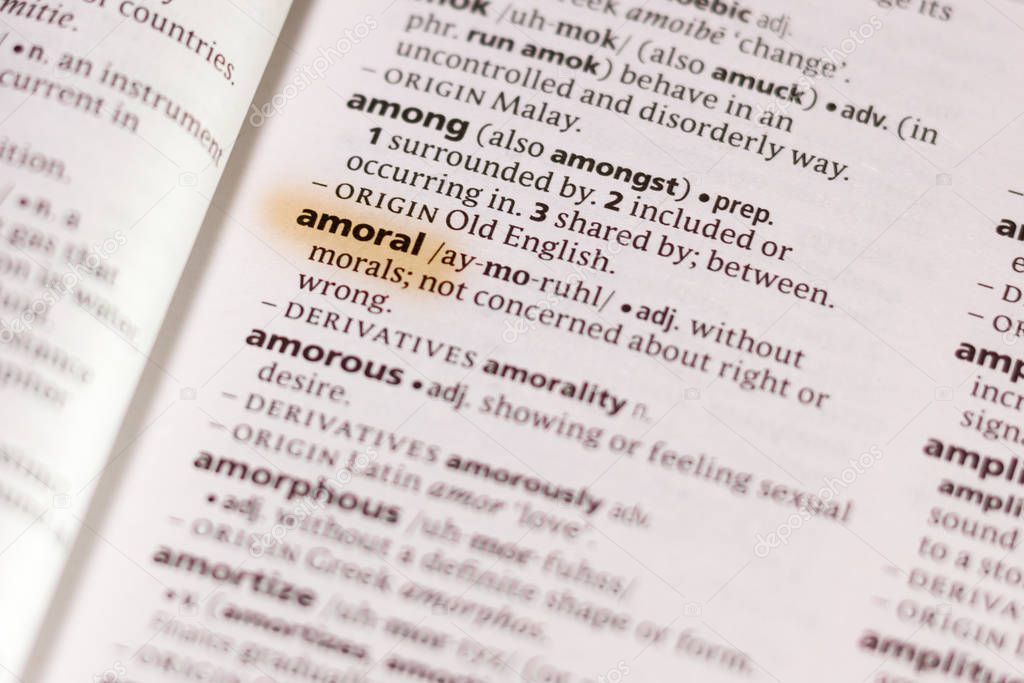The word or phrase Amoral in a dictionary highlighted with marker.