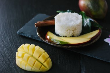 Seramik tabakta pirinçli mango meyveleri.
