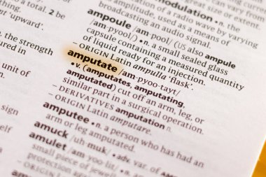 The word or phrase Amputate in a dictionary highlighted with marker.