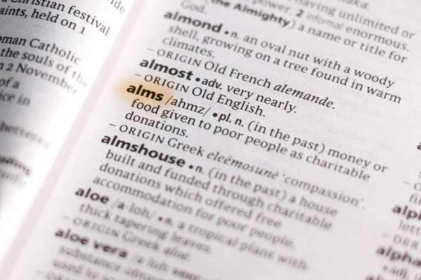 用标记突出显示的词典中的单词或短语 Alms — 图库照片