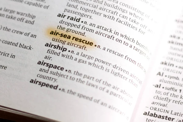 The word or phrase Air-Sea Rescue in a dictionary highlighted with marker.