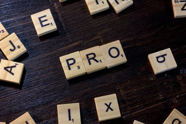 Scrabble betűk Pro szó. — Stock Fotó