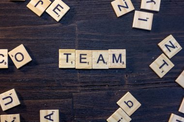 takım kelime ile yapılan scrabble harf üzerinde siyah bir ahşap masa.