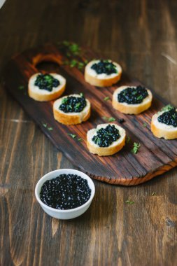 Ahşap mutfak masasının üzerinde siyah havyar.