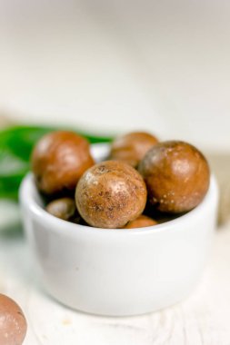 Macadamia fındık ahşap masa üzerinde beyaz seramik kase