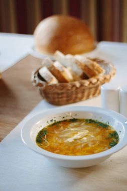 Masadaki beyaz seramik tabakta çorba.