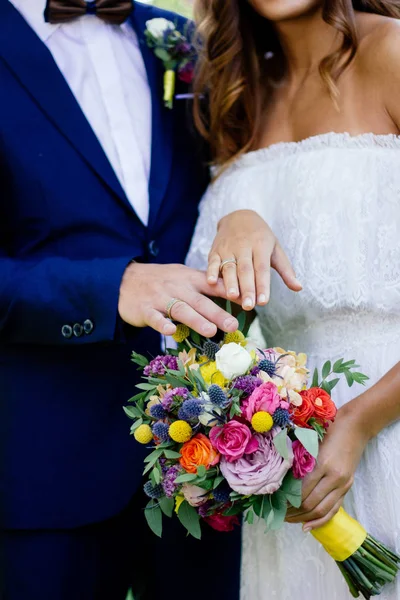 Bruid Bruidegom Demonstreren Ringen Hun Handen Tegen Bloemboeket Als Achtergrond — Stockfoto