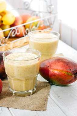 Beyaz ahşap masa üzerinde taze mango smoothie ile Cam
