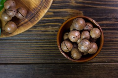 Macadamia fıstığı kahverengi seramik kase üstten görünüm ahşap tablo