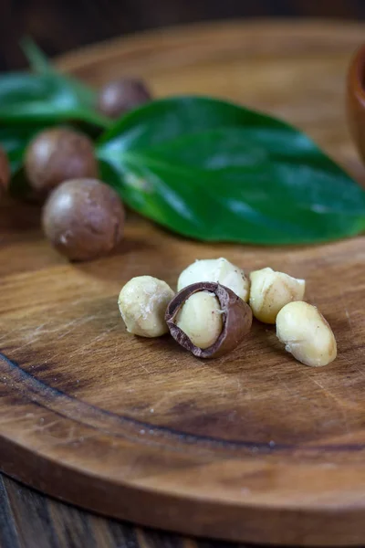 Орехи макадамии на деревянной кухонной доске . — стоковое фото