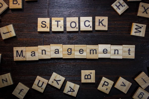 Word or phrase Stock Management made with scrabble letters.