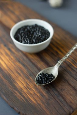 Metal kaşık taze Siyah havyar ahşap kartı ile.