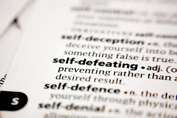 Word or phrase self-defeating in a dictionary. — Stock Photo, Image