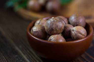 Macadamia fıstığı içinde ile kahverengi seramik kase.