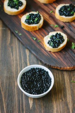 Bir beyaz seramik kase taze siyah havyar.