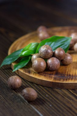 Taze ve olgun macadamiya fındık ahşap tahta üzerinde.