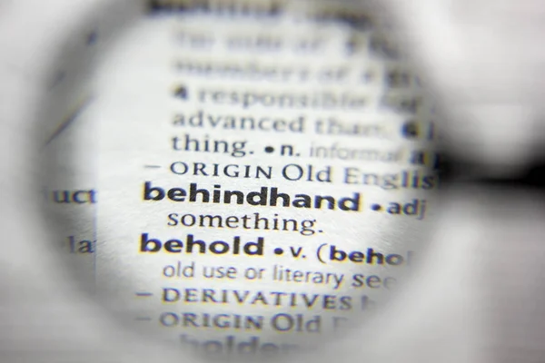 A palavra ou frase behindhand em um dicionário . — Fotografia de Stock