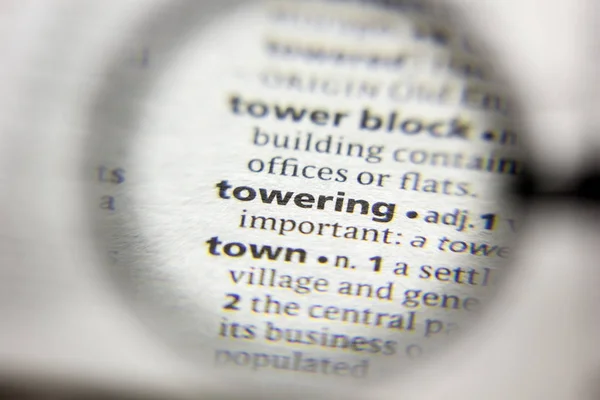 The word or phrase Towering in a dictionary. — Stock Photo, Image